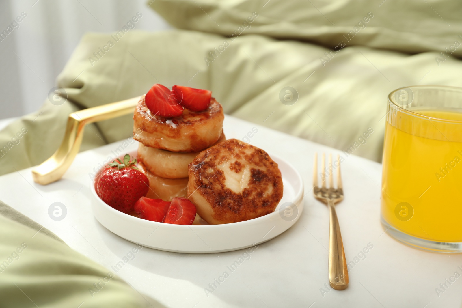 Photo of Cottage cheese pancakes with strawberries and honey served on white bed tray