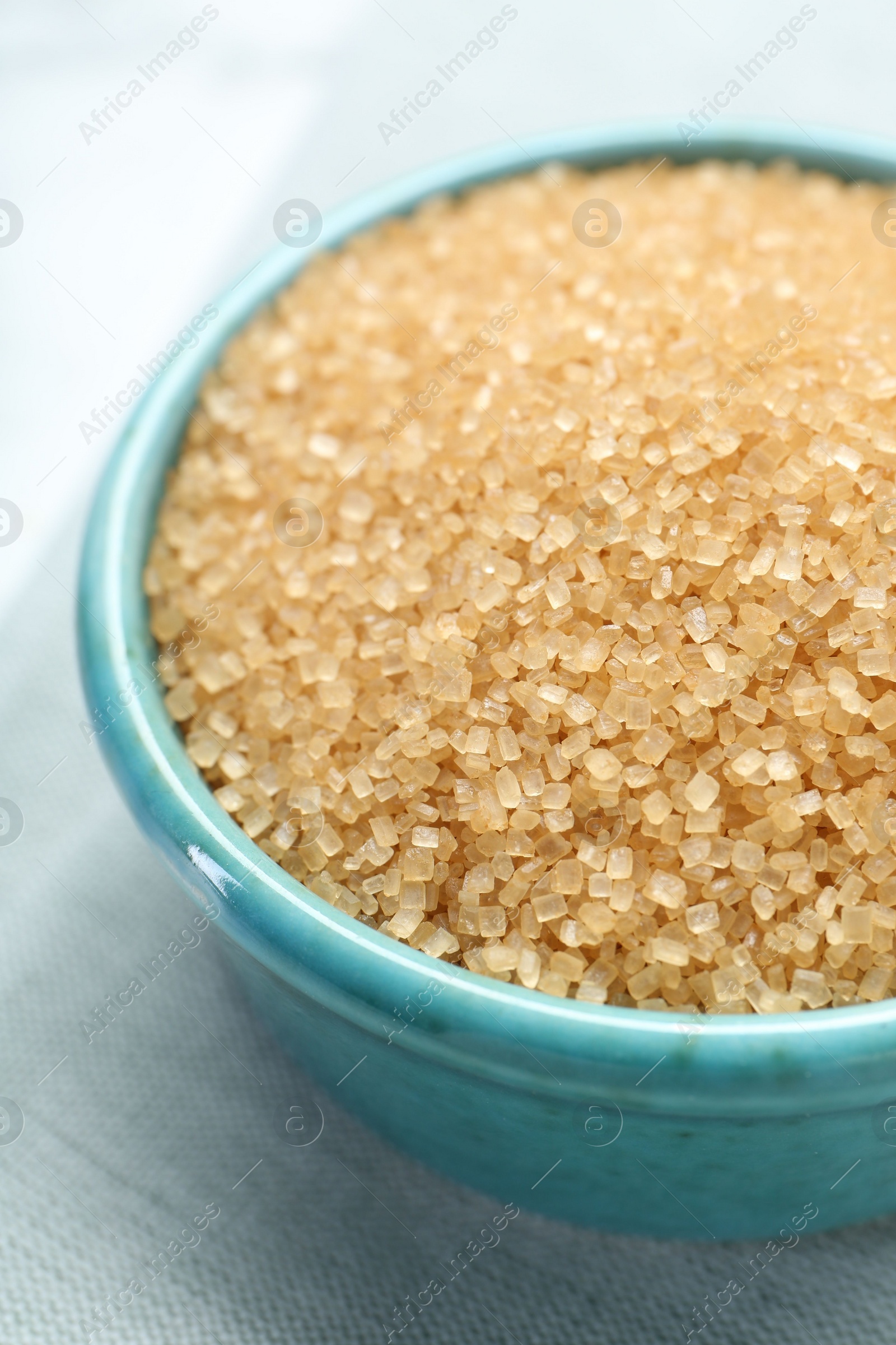 Photo of Brown sugar in bowl on table, closeup