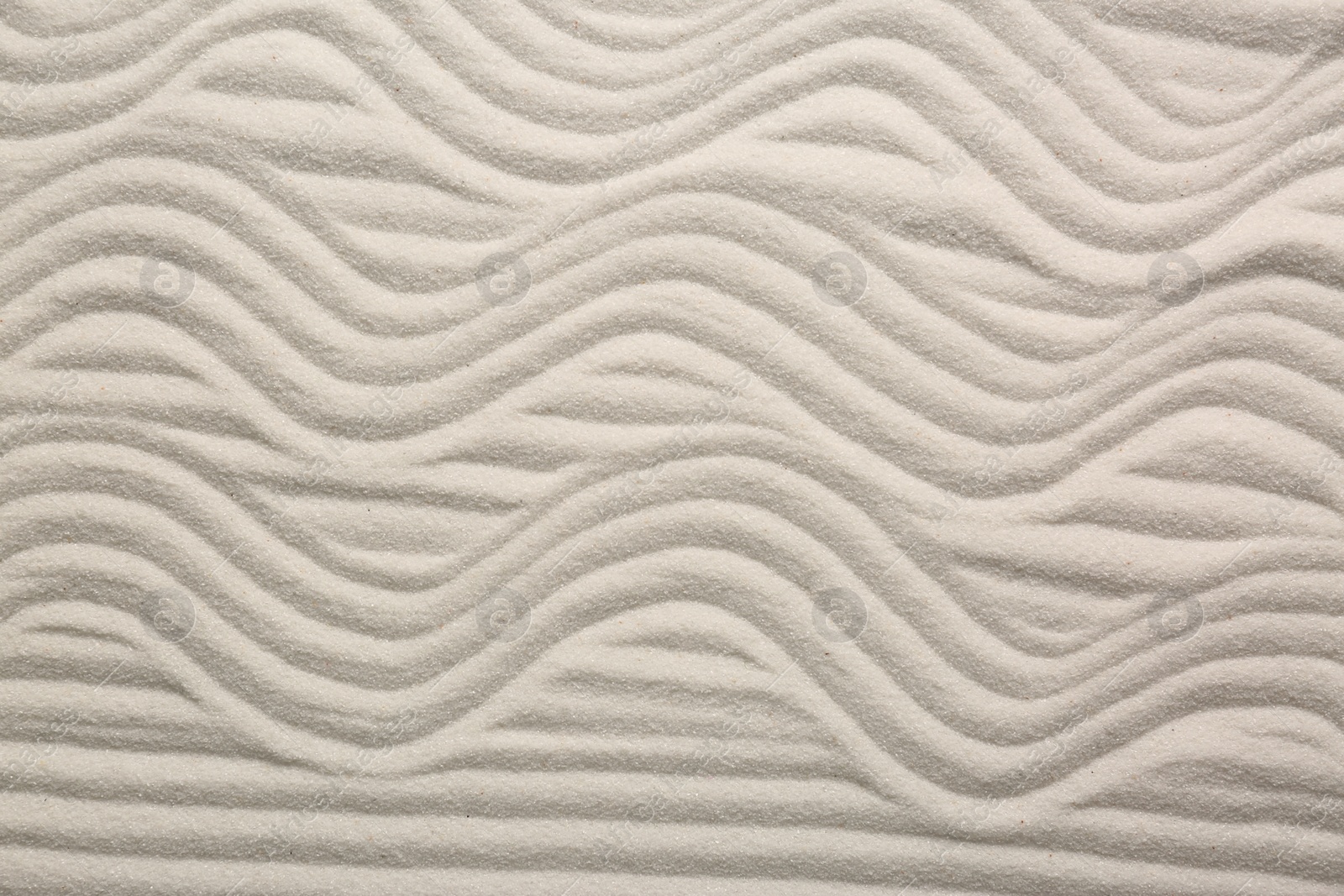 Photo of White sand with pattern as background, top view. Zen concept