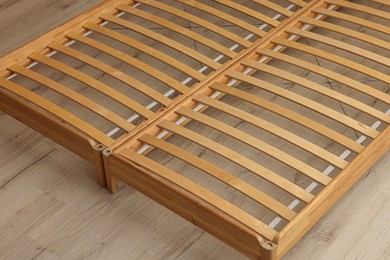 Photo of Wooden bed frame on floor, closeup view