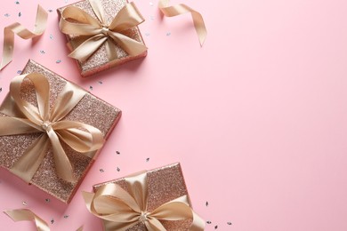 Photo of Three gift boxes and confetti on pink background, flat lay. Space for text