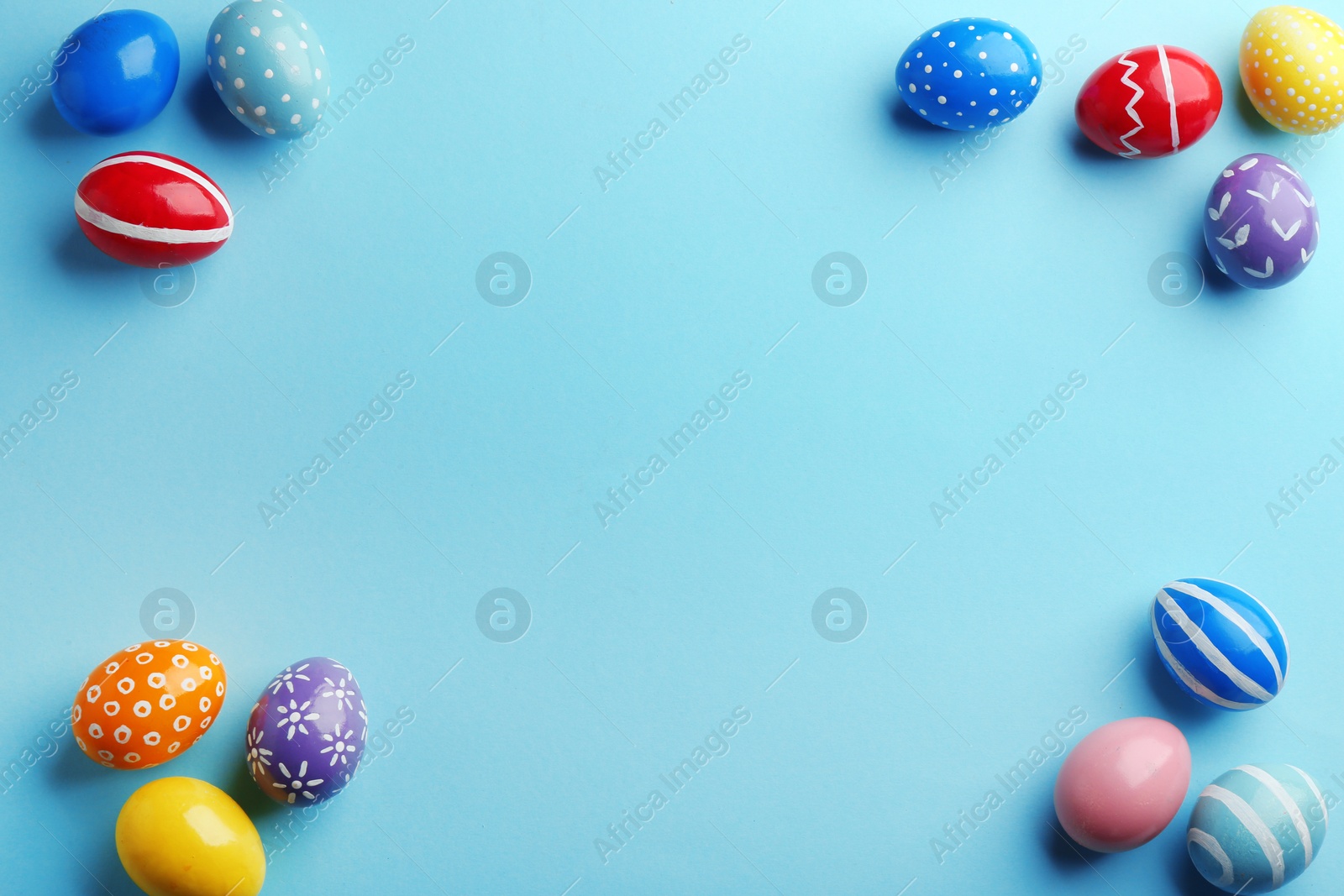 Photo of Flat lay composition of painted Easter eggs on color background, space for text