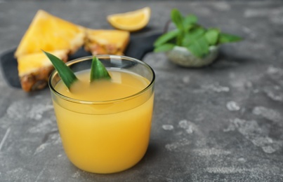 Photo of Glass with delicious pineapple juice on table