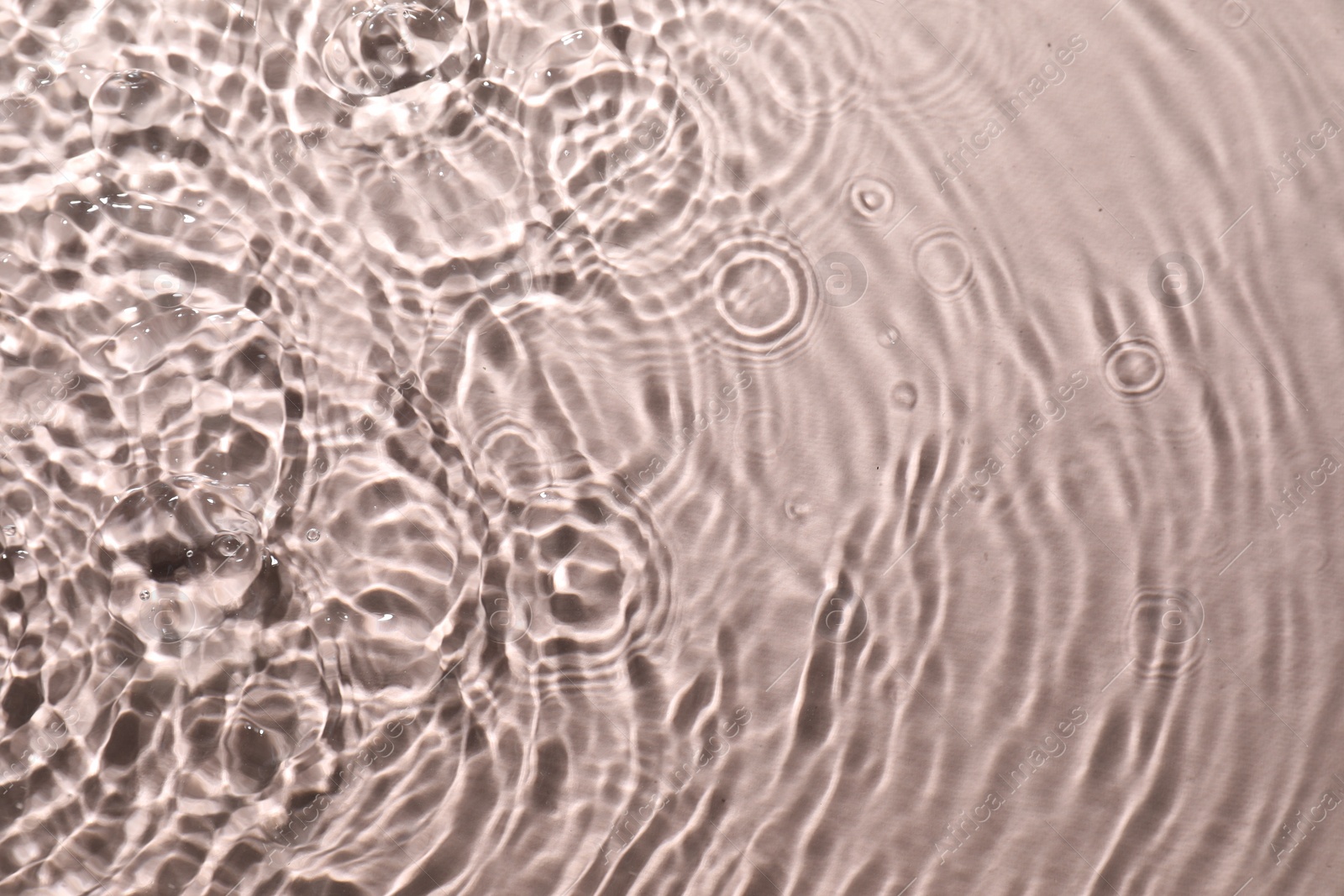 Photo of Rippled surface of clear water on beige background, top view