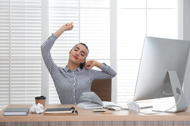 Lazy employee stretching at table in office