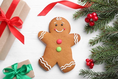 Flat lay composition with gingerbread man and Christmas decor on white wooden table