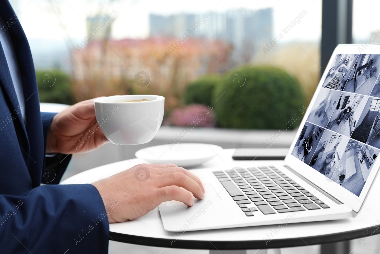 Image of Man monitoring modern cctv cameras on laptop indoors, closeup. Home security system