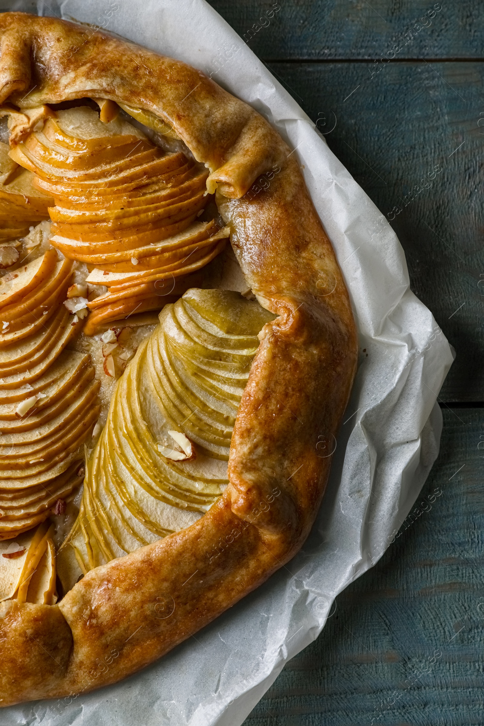 Photo of Delicious apple galette with walnuts on wooden table, top view