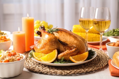 Photo of Delicious roasted turkey with garnish on dinner table