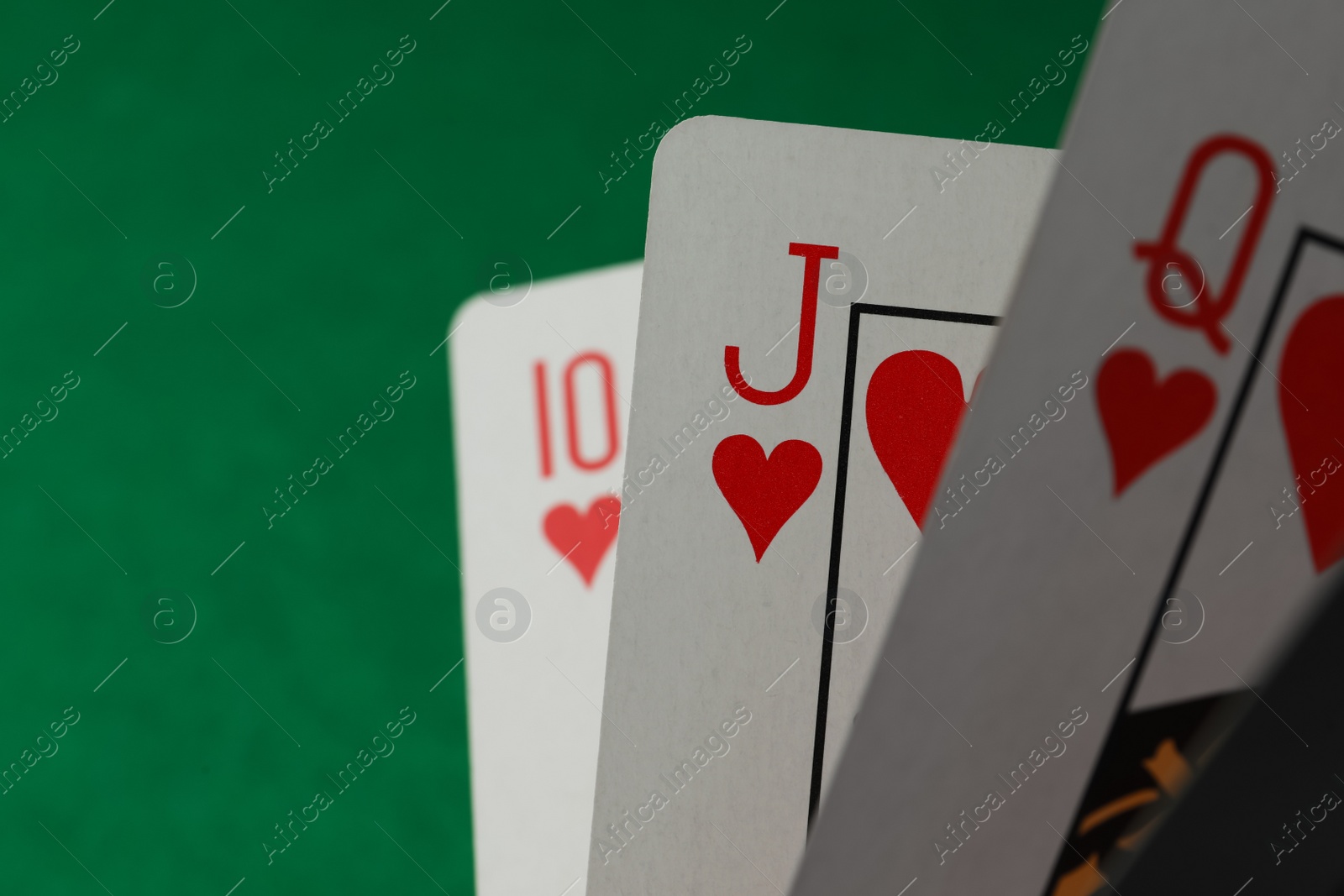 Photo of Hand of playing cards on green background, closeup. Space for text