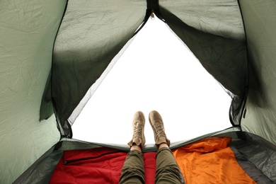 Photo of Closeup of female in camping tent on white background, view from inside