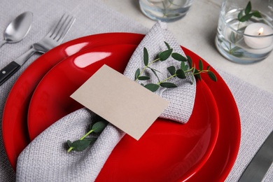 Elegant festive table setting with blank card on grey background, closeup