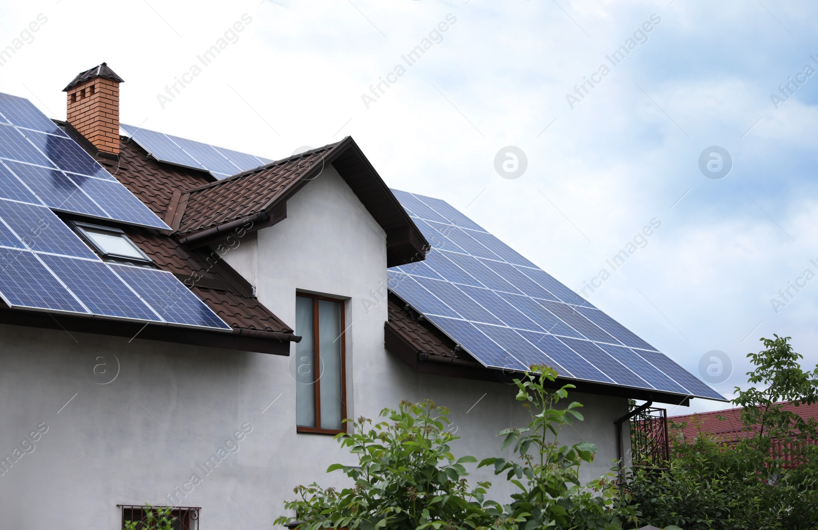 Photo of House with installed solar panels on roof. Alternative energy source