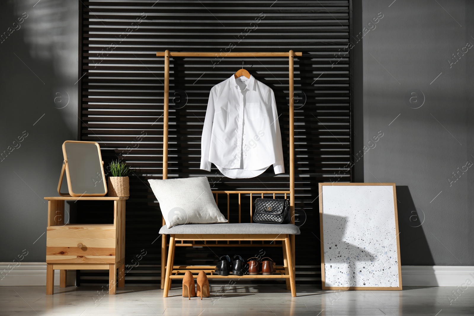 Photo of Hallway interior with modern furniture, mirror and hanging shirt