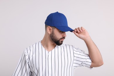 Man in stylish blue baseball cap on white background