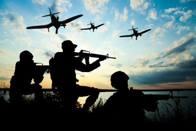 Image of Silhouettes of soldiers in uniform with assault rifles and military airplanes patrolling outdoors