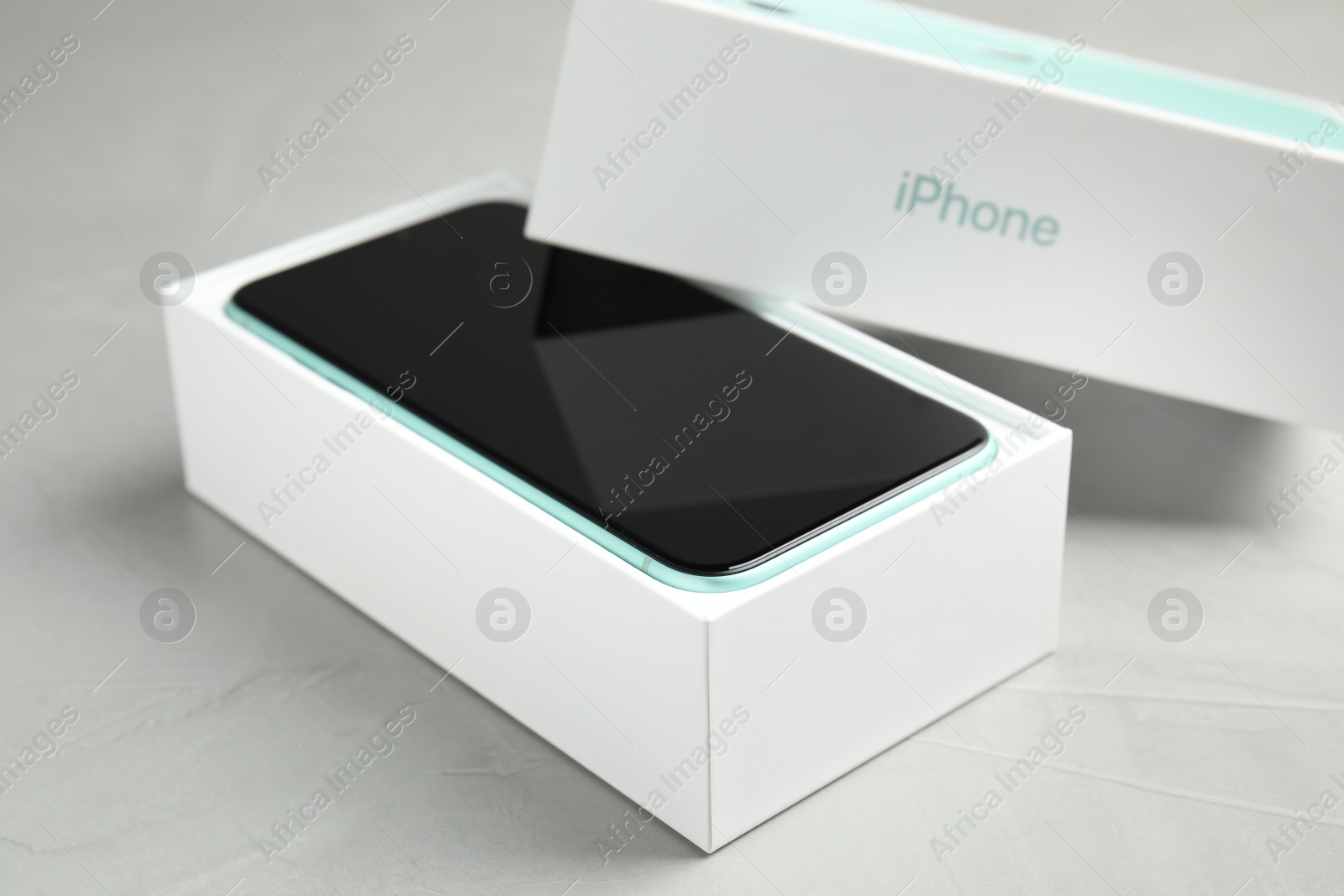 Photo of MYKOLAIV, UKRAINE - JULY 10, 2020: New modern Iphone 11 in original box on light grey table