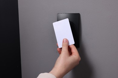 Photo of Woman opening magnetic door lock with key card, closeup. Home security