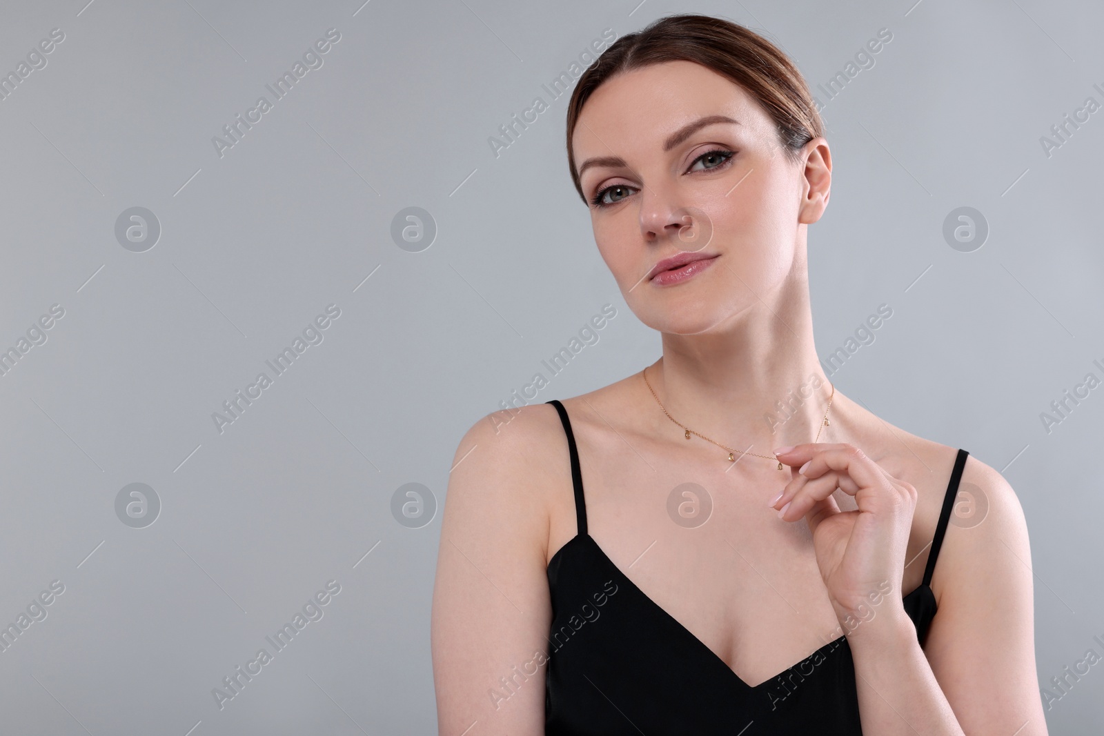 Photo of Beautiful woman with elegant necklace on light grey background. Space for text