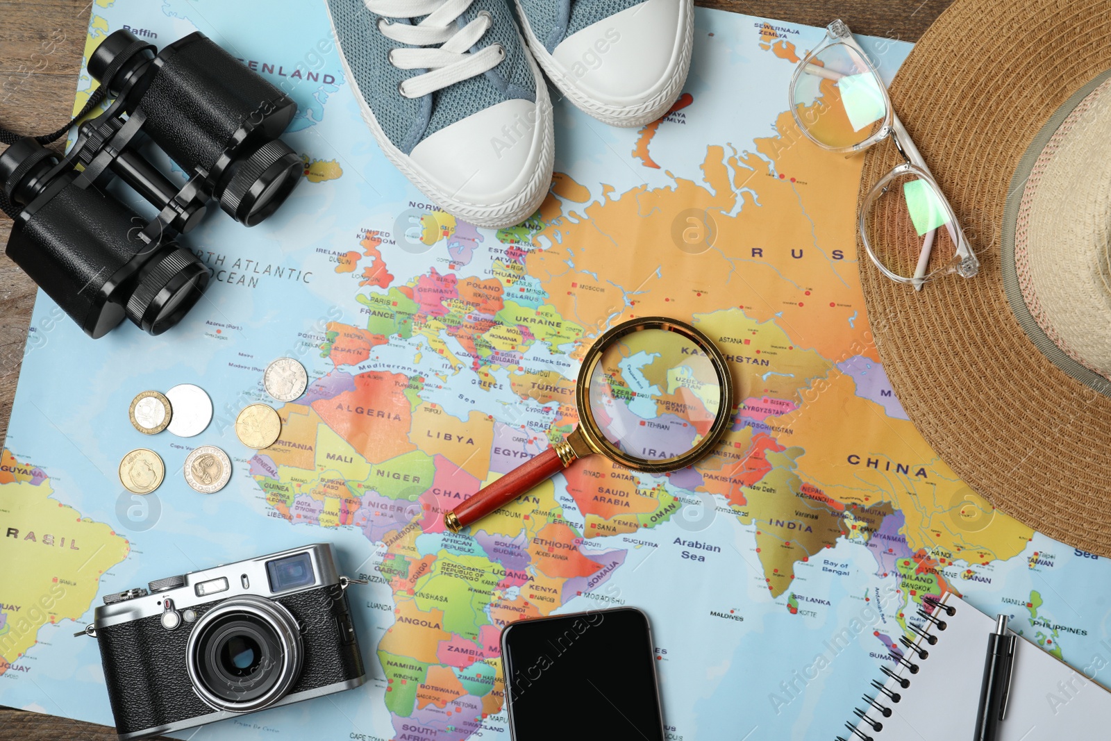 Photo of Flat lay composition with world map and different travel accessories on wooden table. Planning summer vacation trip