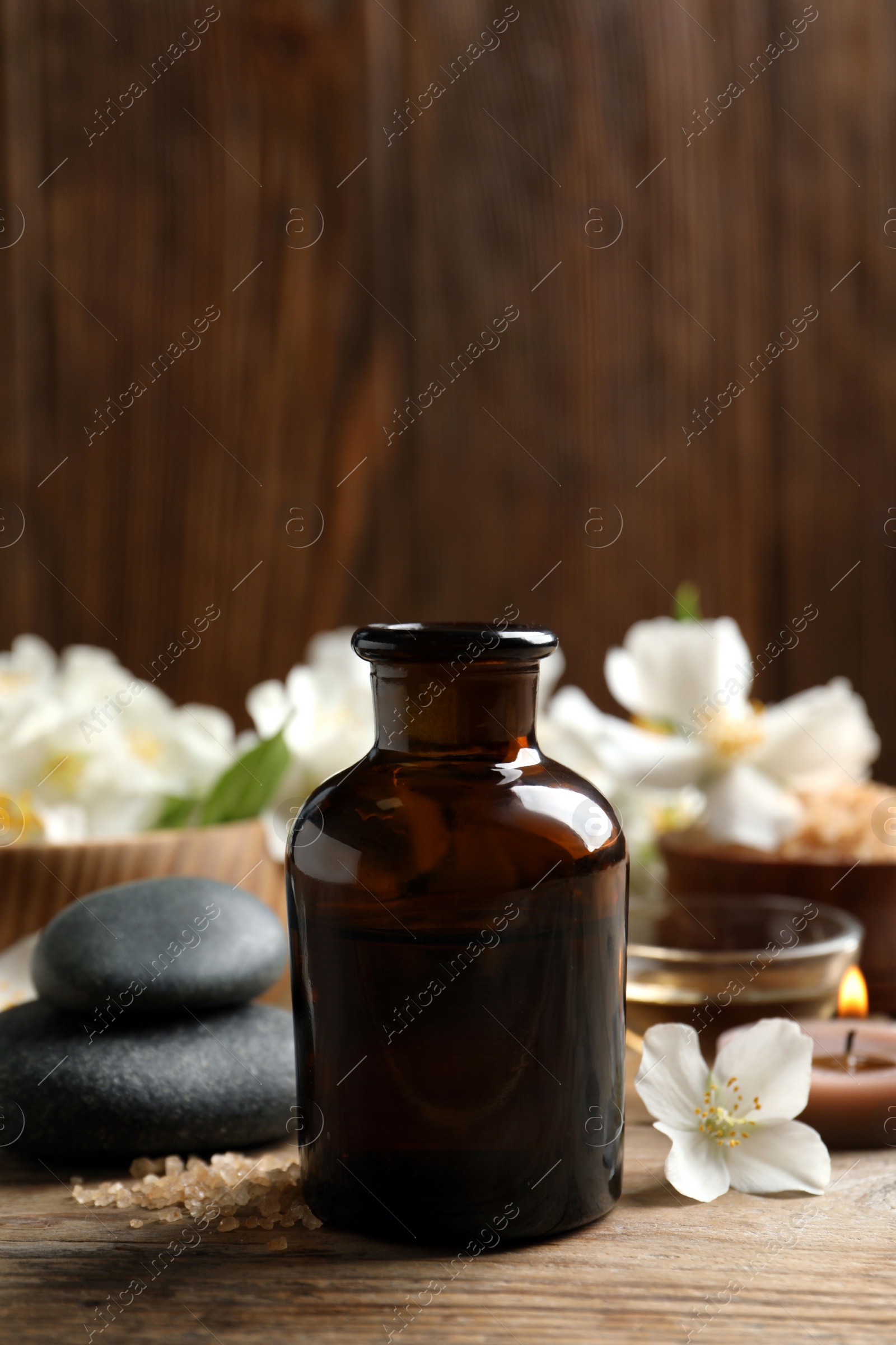 Photo of Beautiful composition with jasmine essential oil and fresh flowers on wooden table