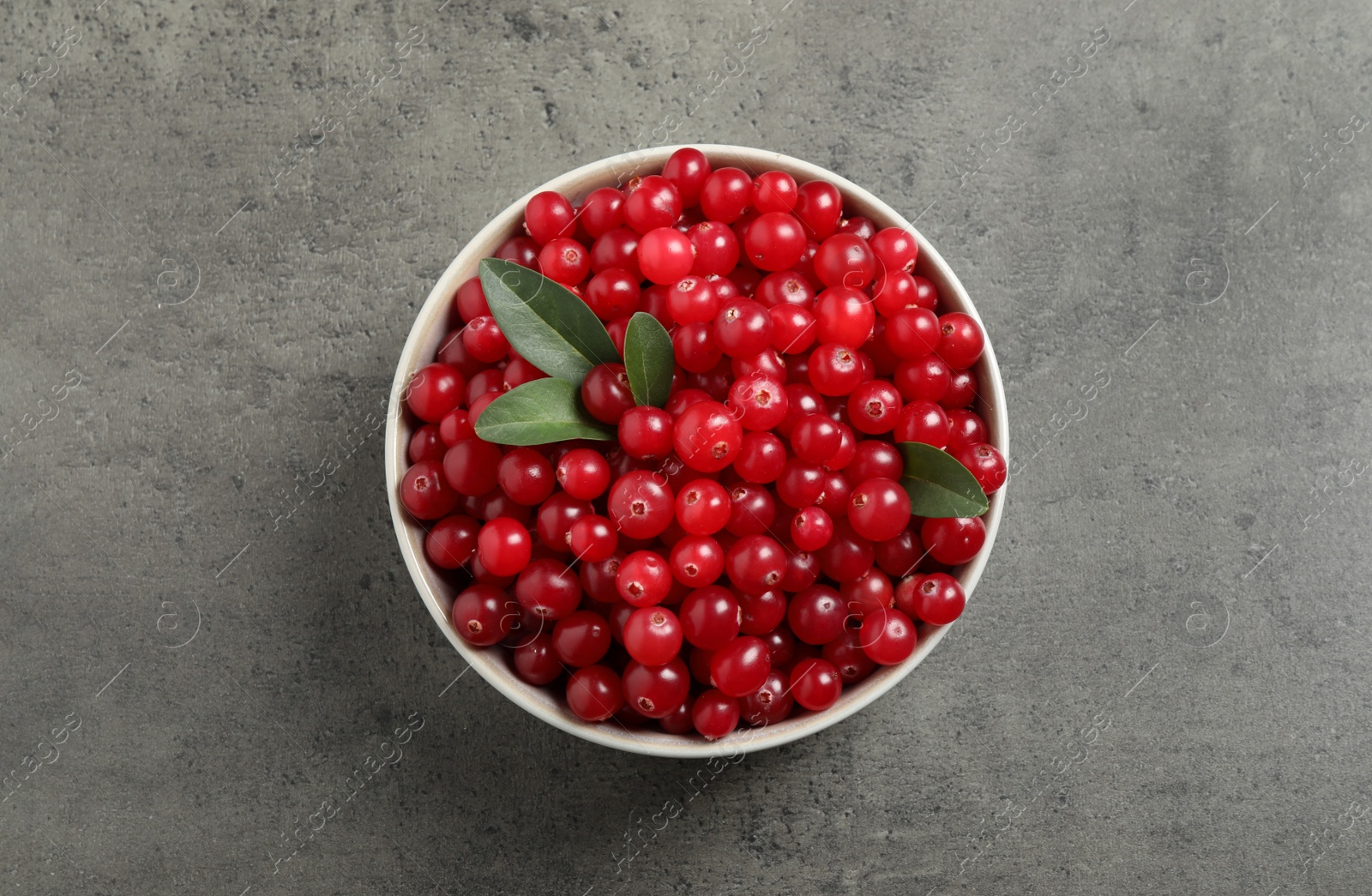 Photo of Ripe fresh cranberry on grey table, top view