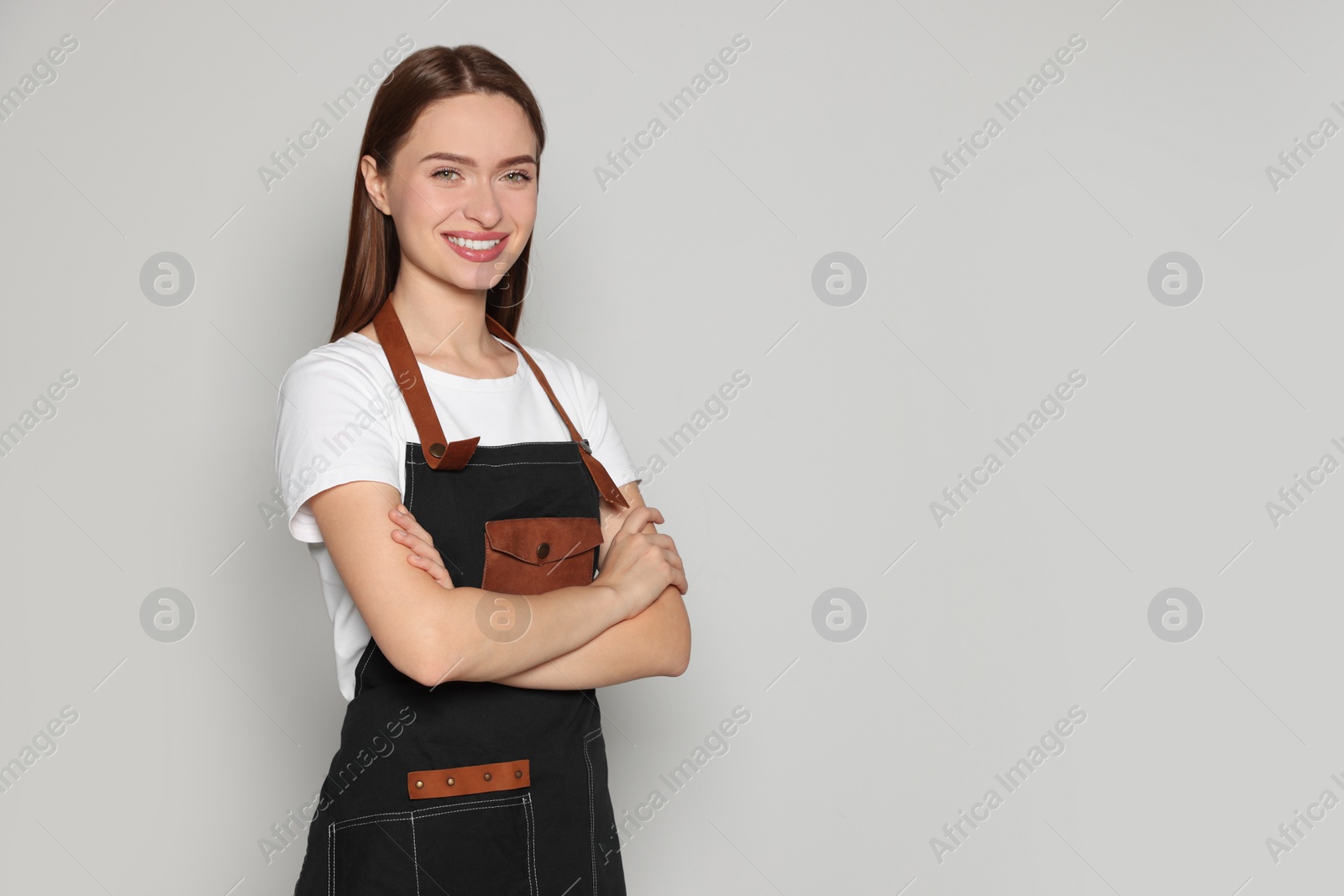 Photo of Portrait of happy hairdresser on light background. Space for text