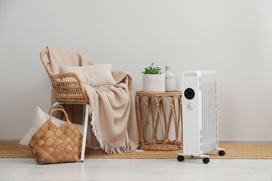 Photo of Modern portable electric heater near furniture indoors