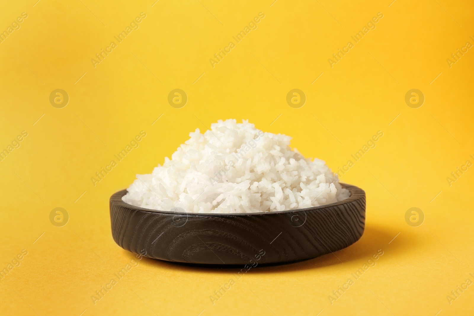 Photo of Bowl of boiled rice on color background