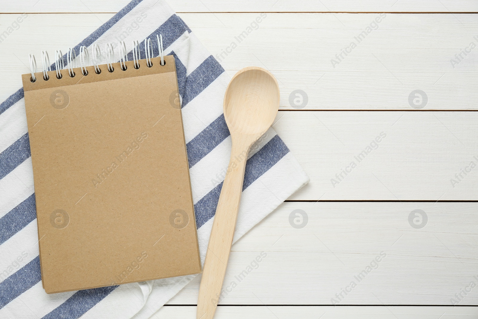 Photo of Blank recipe book and spoon on white wooden table, flat lay. Space for text