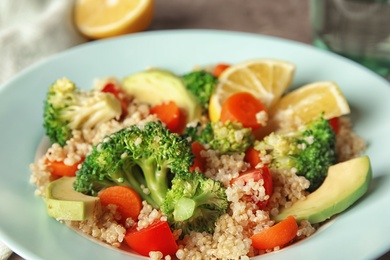 Photo of Tasty salad with quinoa in color plate, closeup