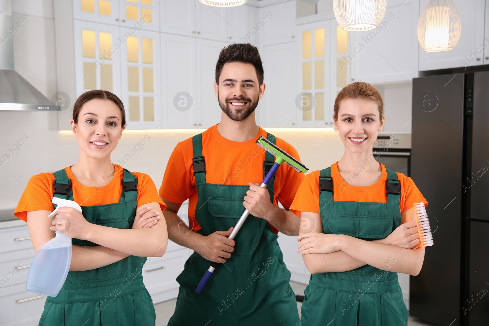 Photo of Team of professional janitors in kitchen. Cleaning service