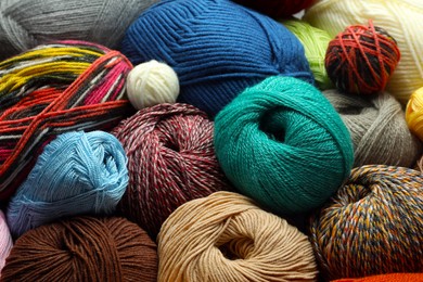 Photo of Different balls of woolen knitting yarns as background, closeup