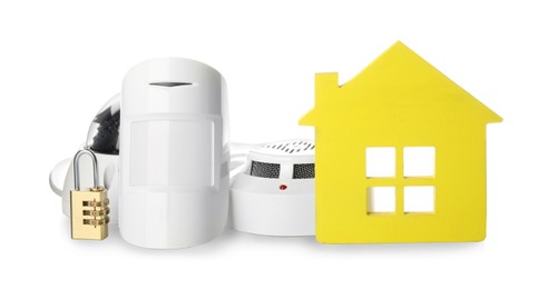 Photo of House model, CCTV camera, lock, smoke and movement detectors on white background. Home security system