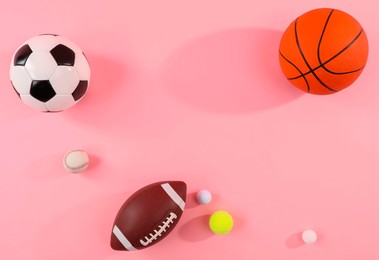 Photo of Many different sports balls on pink background, flat lay. Space for text