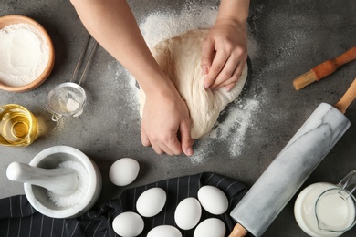 Female baker preparing bread dough at kitchen table, top view