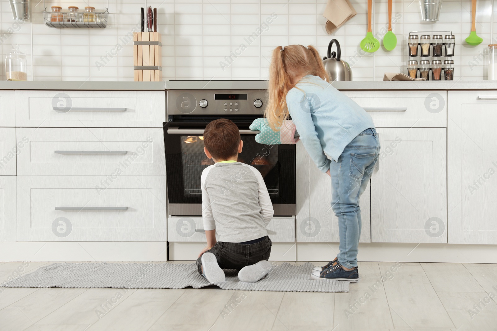 Photo of Little kids baking buns in oven at home