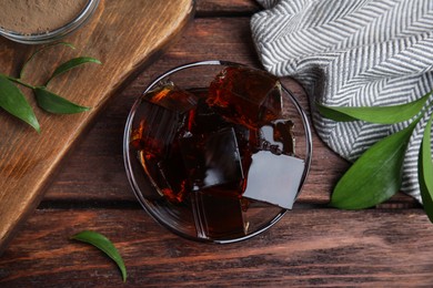 Photo of Delicious grass jelly cubes on wooden table, flat lay