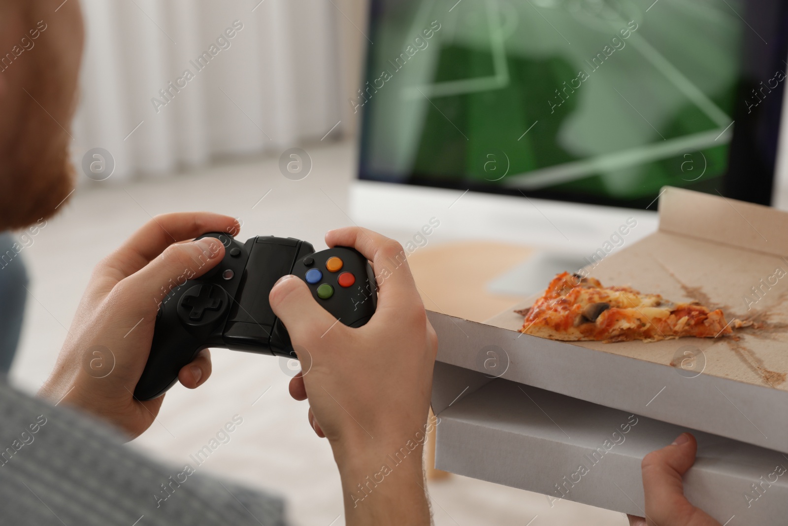 Photo of Young man playing video games at home, closeup