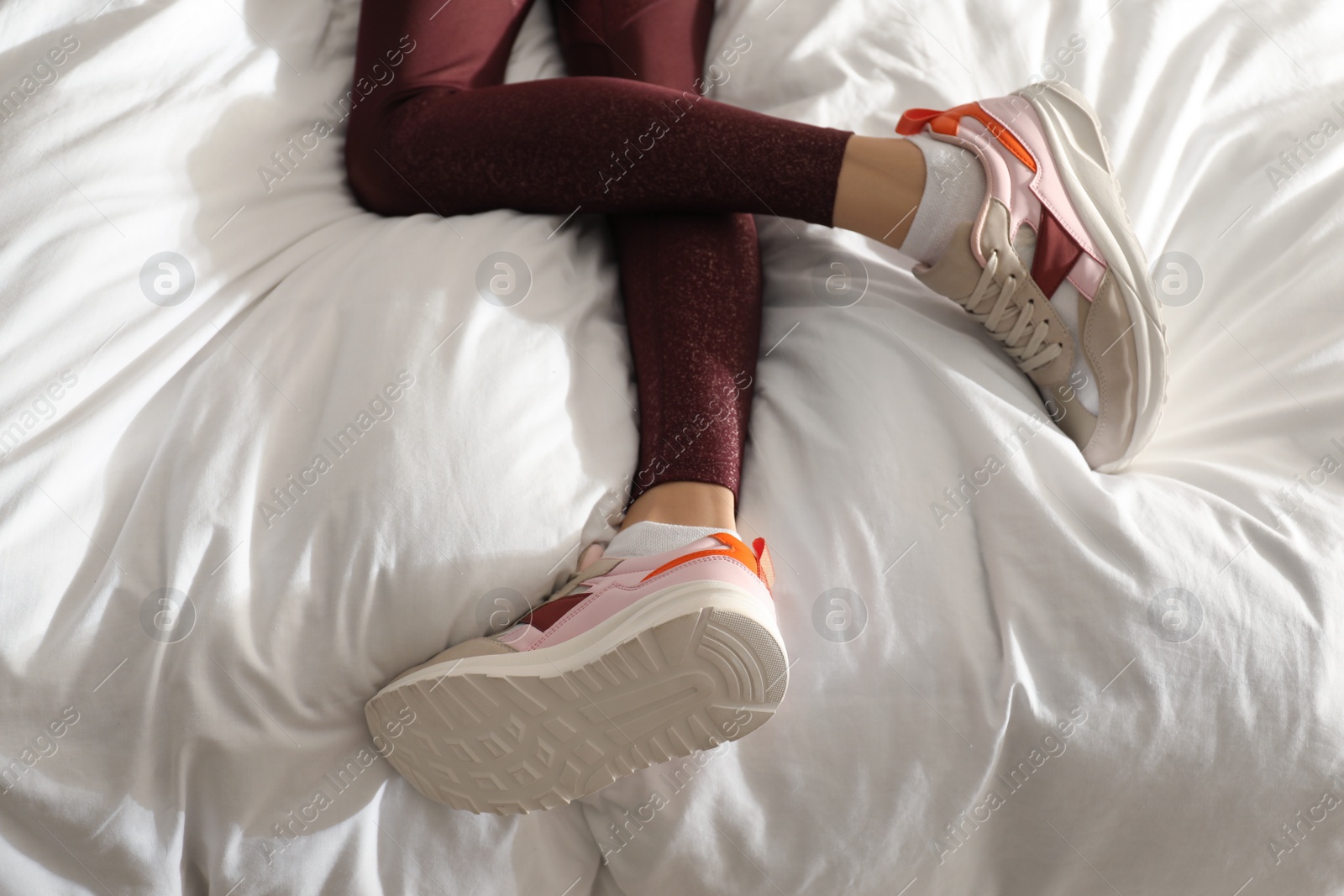 Photo of Lazy young woman sleeping on bed instead of morning training, closeup