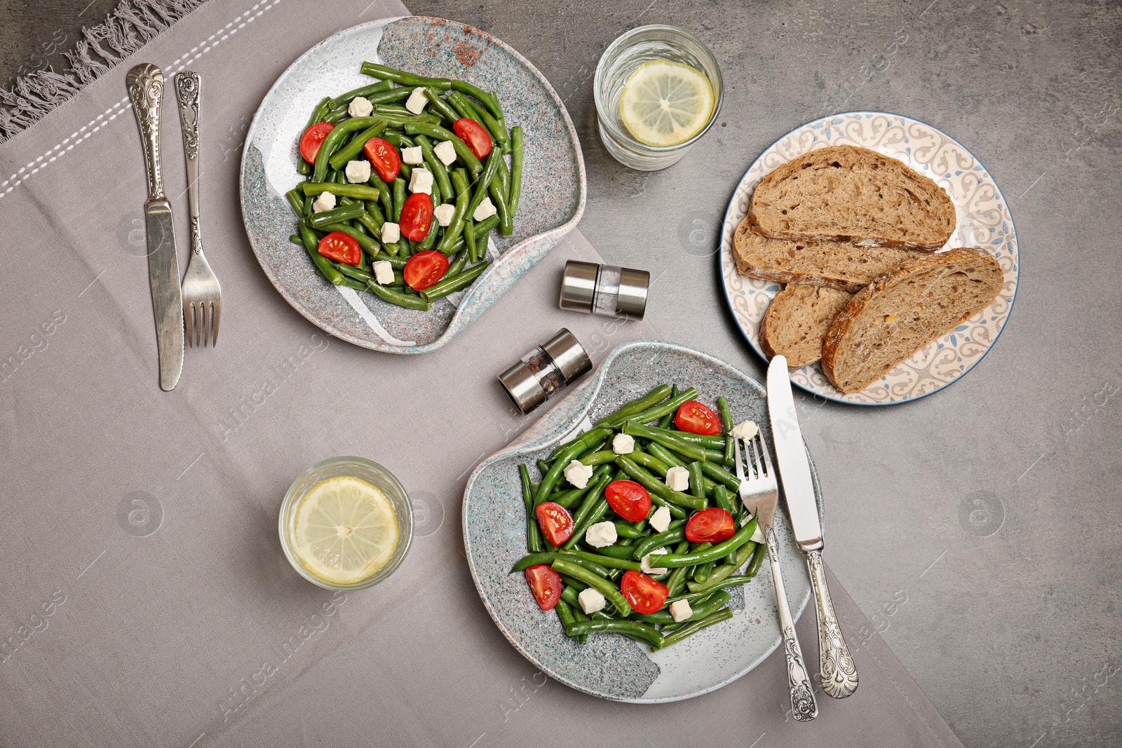 Photo of Plates with tasty green beans, tomatoes and cheese on table, top view