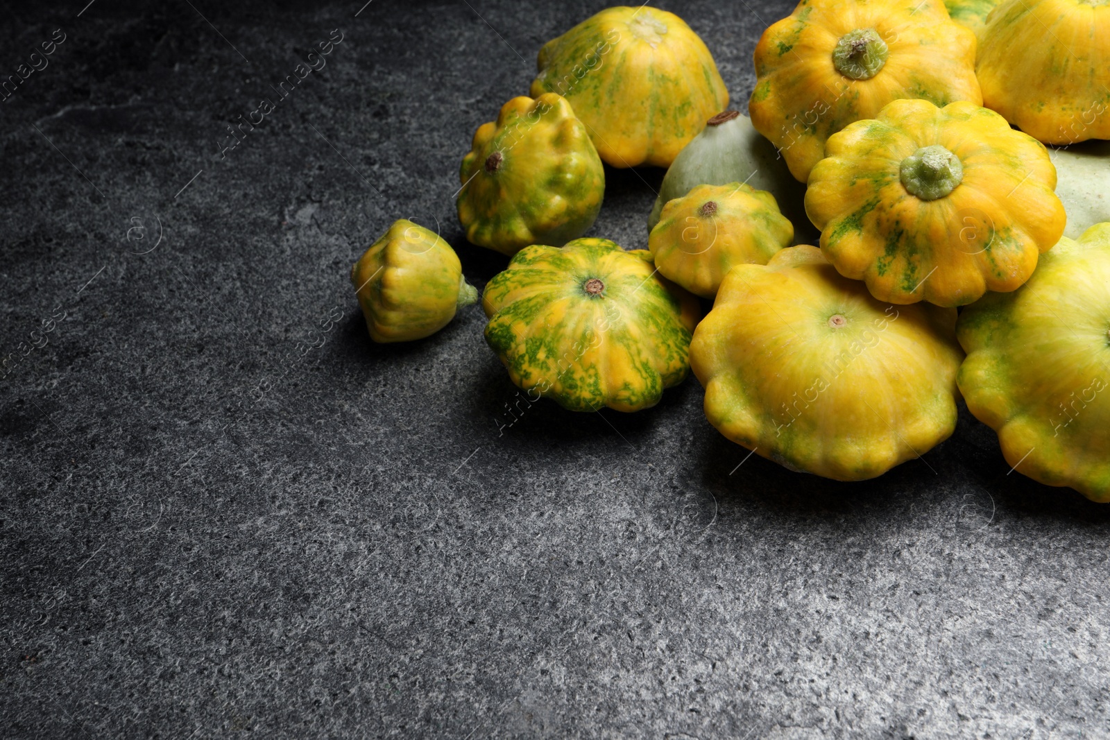 Photo of Fresh ripe pattypan squashes on grey table. Space for text