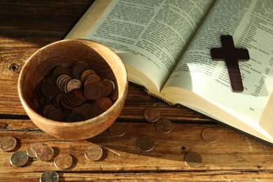 Photo of Donate and give concept. Bowl with coins, cross and Bible on wooden table