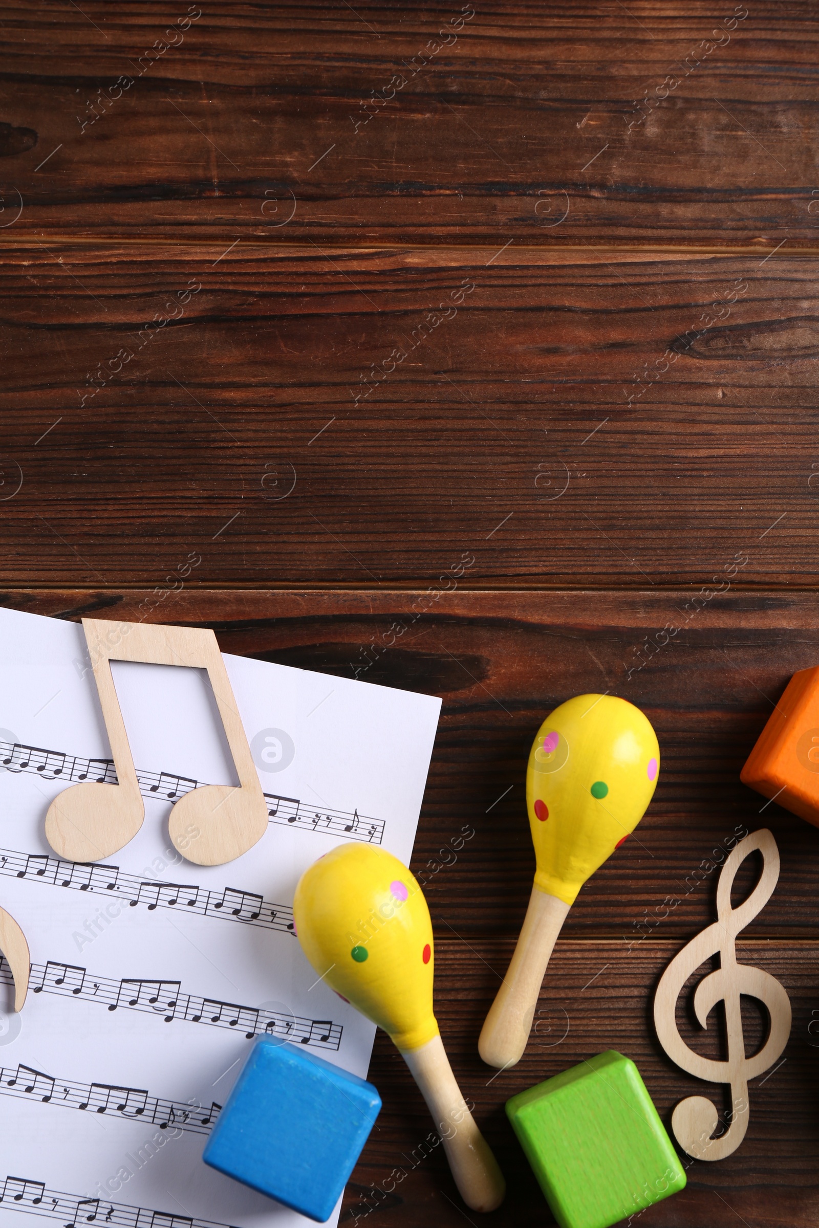 Photo of Baby song concept. Wooden notes, music sheet and toys on table, flat lay. Space for text