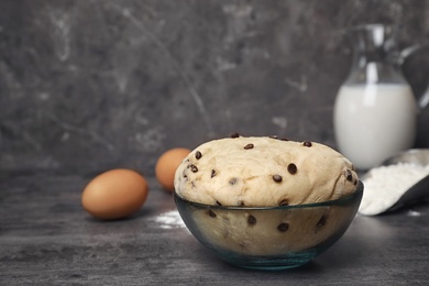 Raw wheat dough with chocolate chips in bowl on table