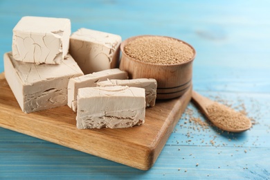 Compressed and granulated yeast on light blue wooden table