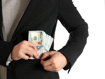 Photo of Man putting bribe money into pocket on white background, closeup