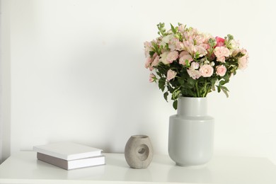 Beautiful bouquet of fresh flowers in vase on white table indoors, space for text