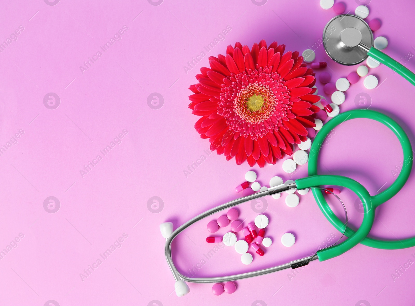 Photo of Flat lay composition with stethoscope, flower and pills on color background. Gynecological checkup