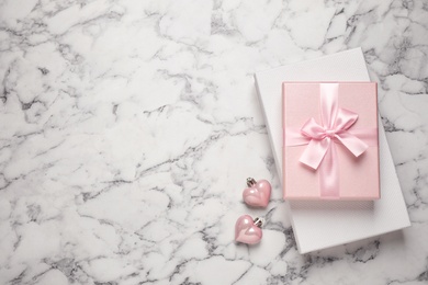 Photo of Beautiful gift boxes and festive decor on white marble table, flat lay. Space for text